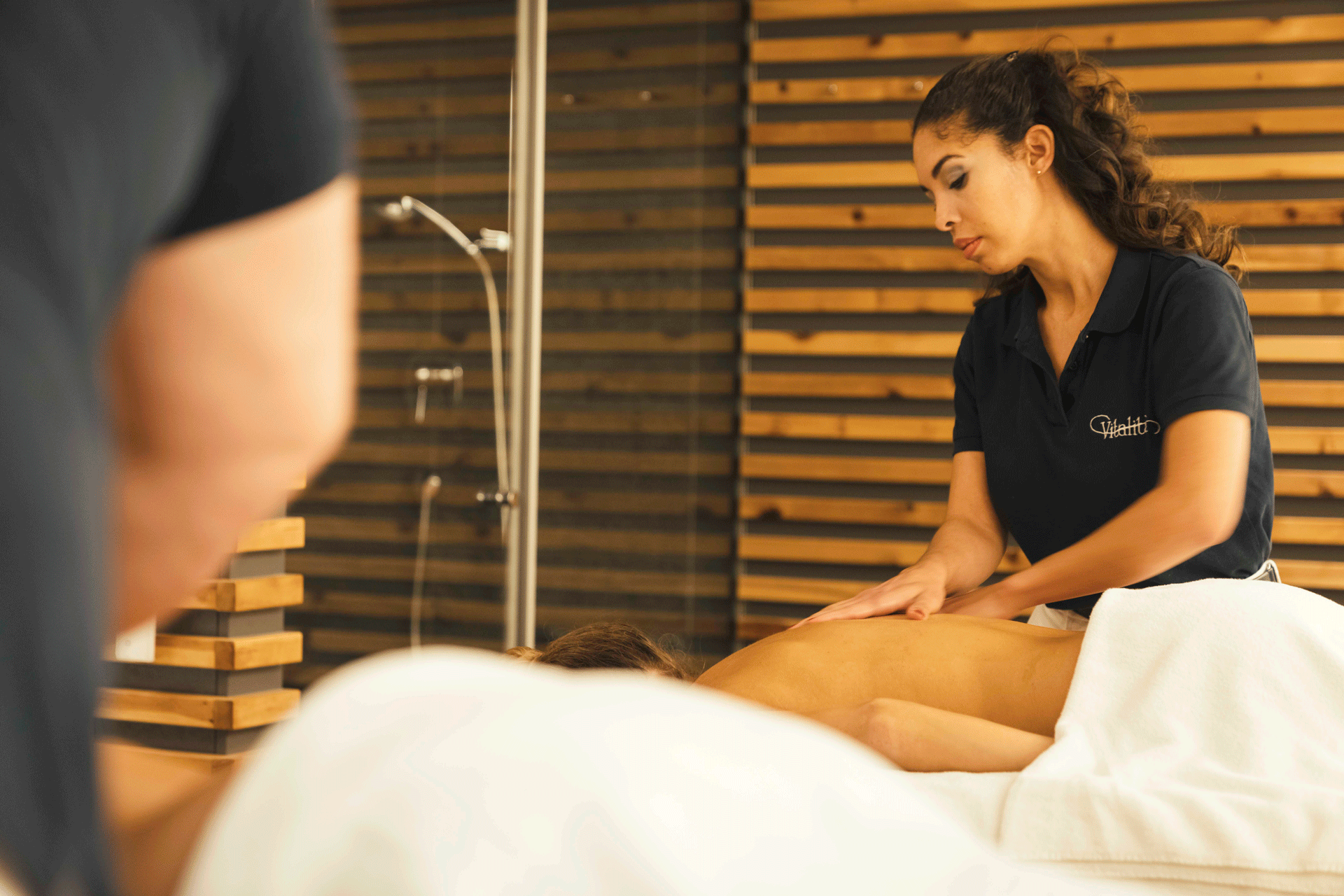 Frau massiert einer anderen Frau den Rücken