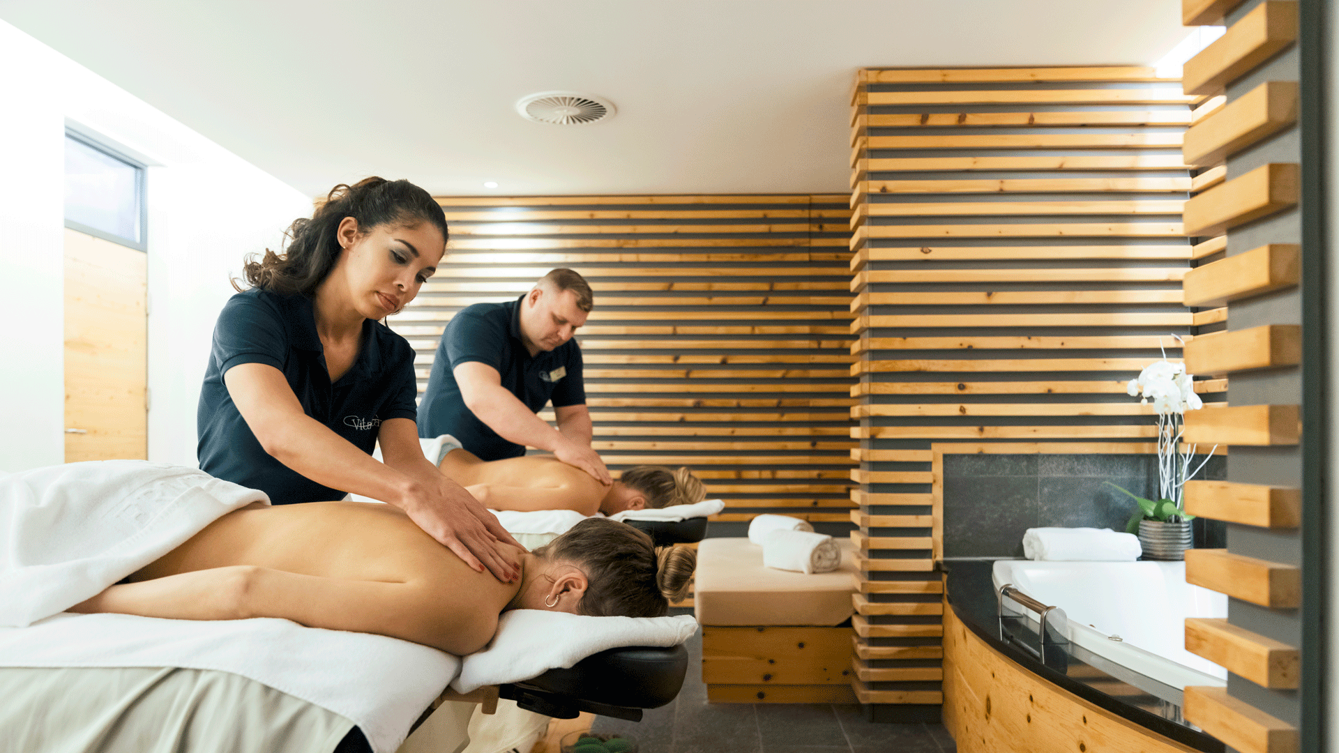 Massage à l'hôtel Ermitage Deux femmes se font masser les épaules par une femme et un homme