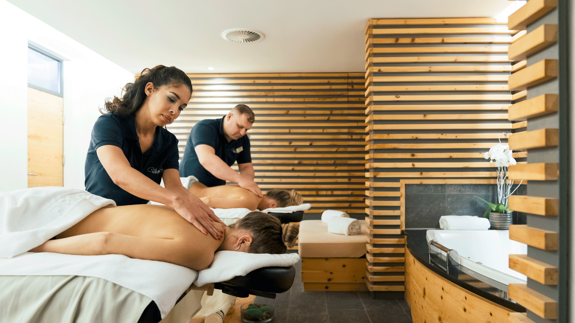 Massage im Hotel Ermitage Zwei Frauen werden an den Schultern massiert von einer Frau und einem Mann