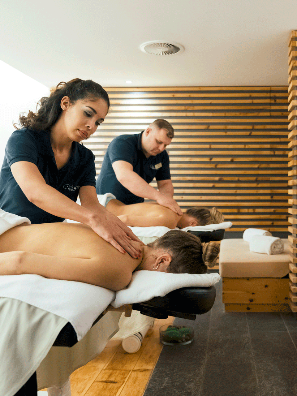 Massage im Hotel Ermitage Zwei Frauen werden an den Schultern massiert von einer Frau und einem Mann