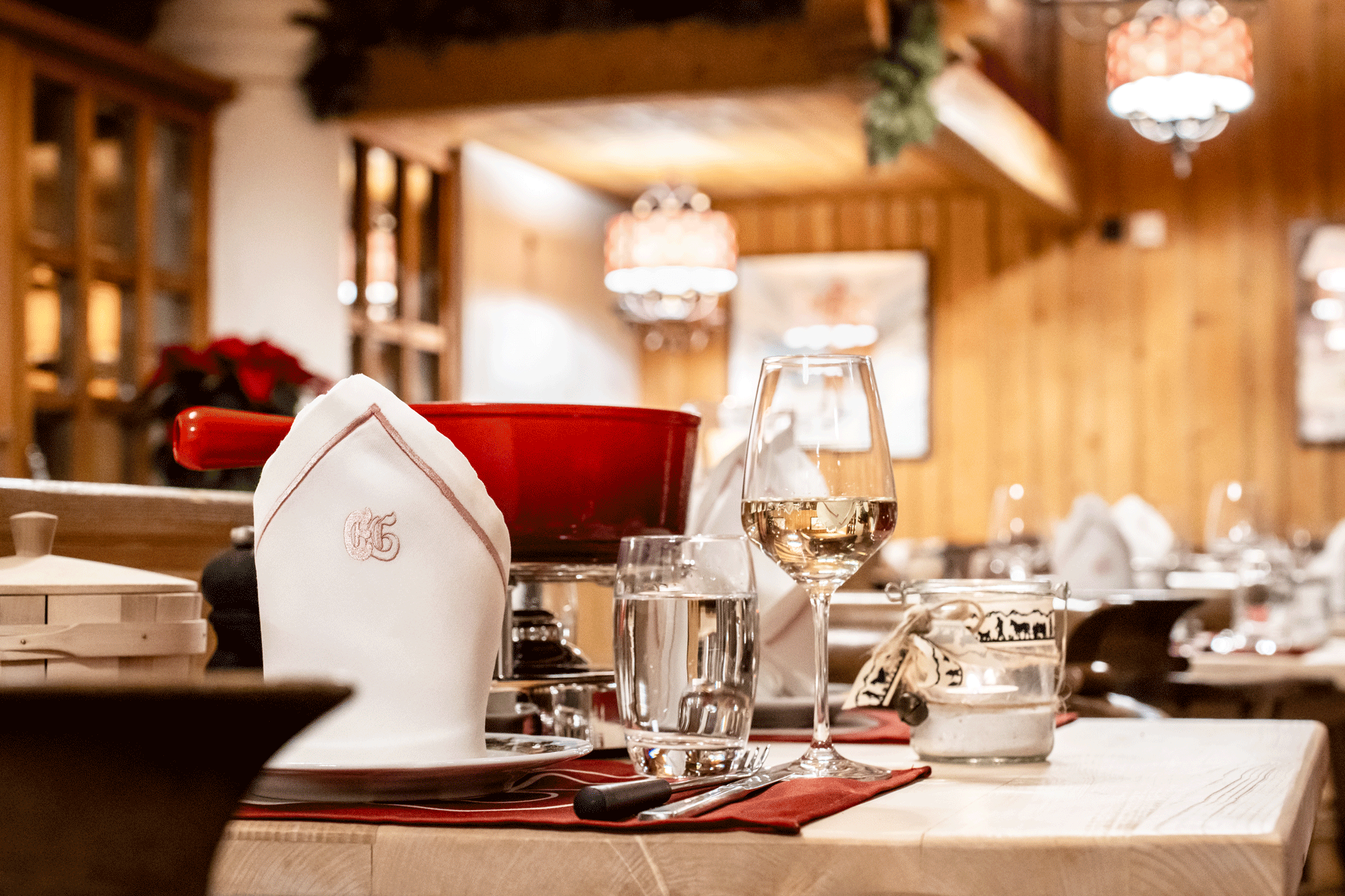 Gedeckter Tisch mit Fondue-Caquelon und Wein