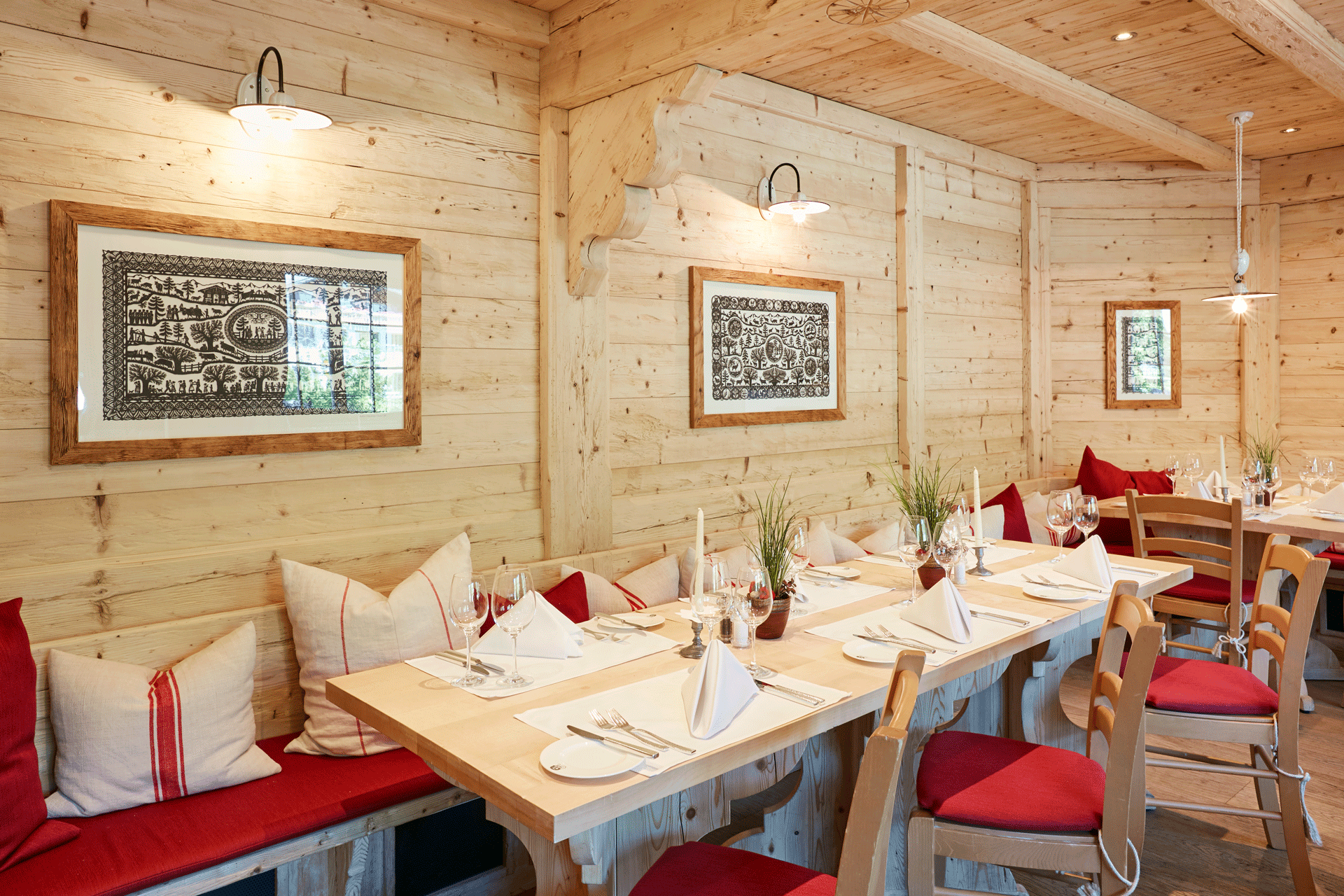 Restaurant revêtu de bois clair, tables en bois couvertes, silhouettes au mur