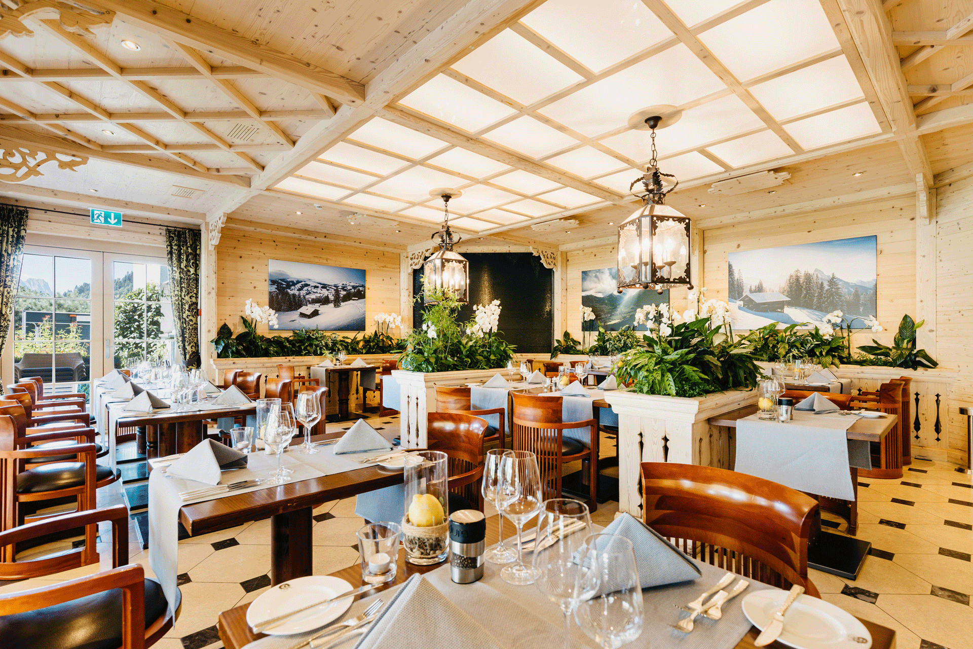 Restaurant avec dalles de sol noires et blanches, lucarne et porte vitrée donnant sur la terrasse