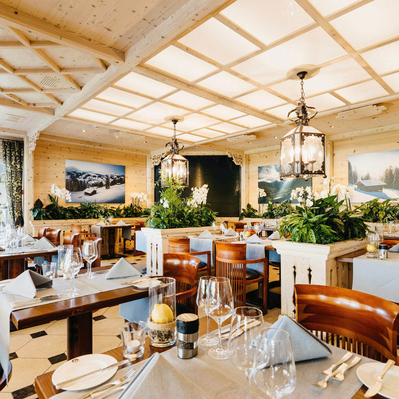 Orangerie im Hotel Ermitage Restaurant mit schwarz-weissen Bodenplatten, Oberlichte und Glastür zur Terrasse