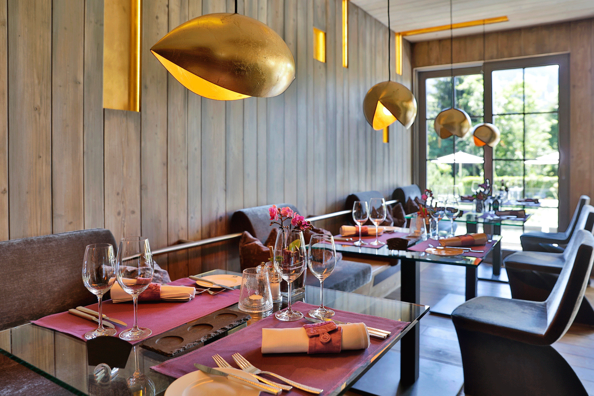 Restaurant mit Holztäfelung und goldenen Hängelampen