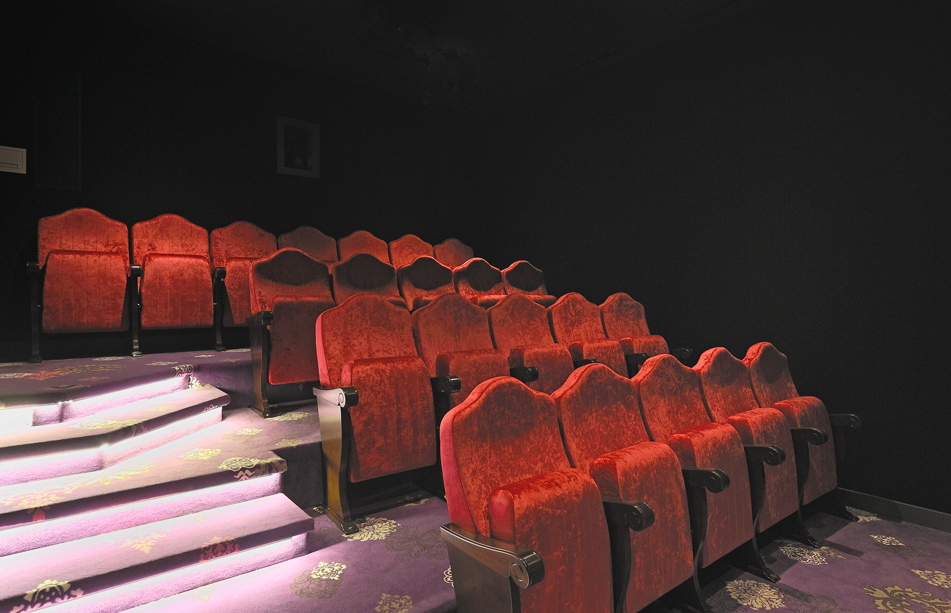 Rote Kinoklappsessel und samtener Boden