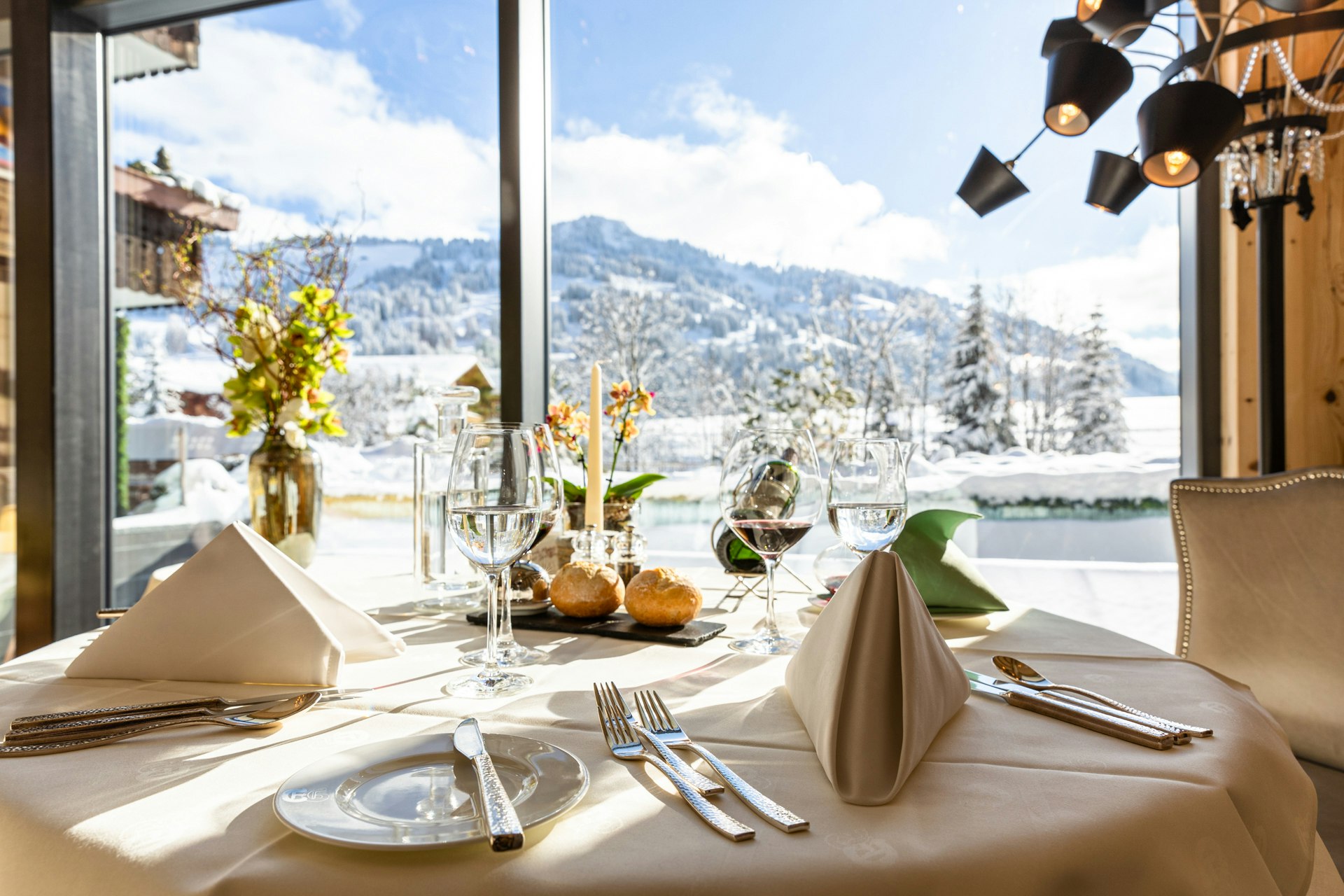 Petit déjeuner avec champagne sur une table, derrière une grande fenêtre avec vue sur le jardin