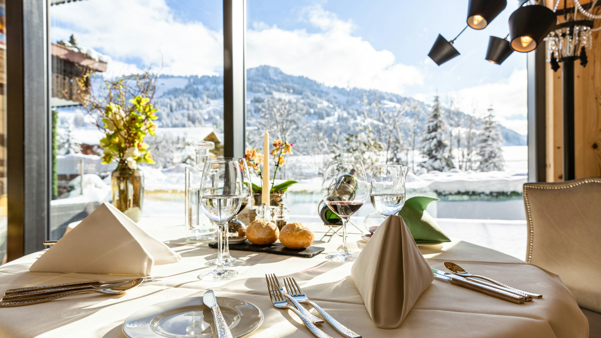 Lobby at the Hotel Ermitage Breakfast with sparkling wine on a table, behind a large window with a view of the garden