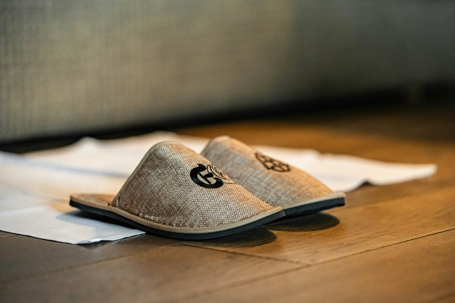 Chaussures de bain avec logo devant un lit