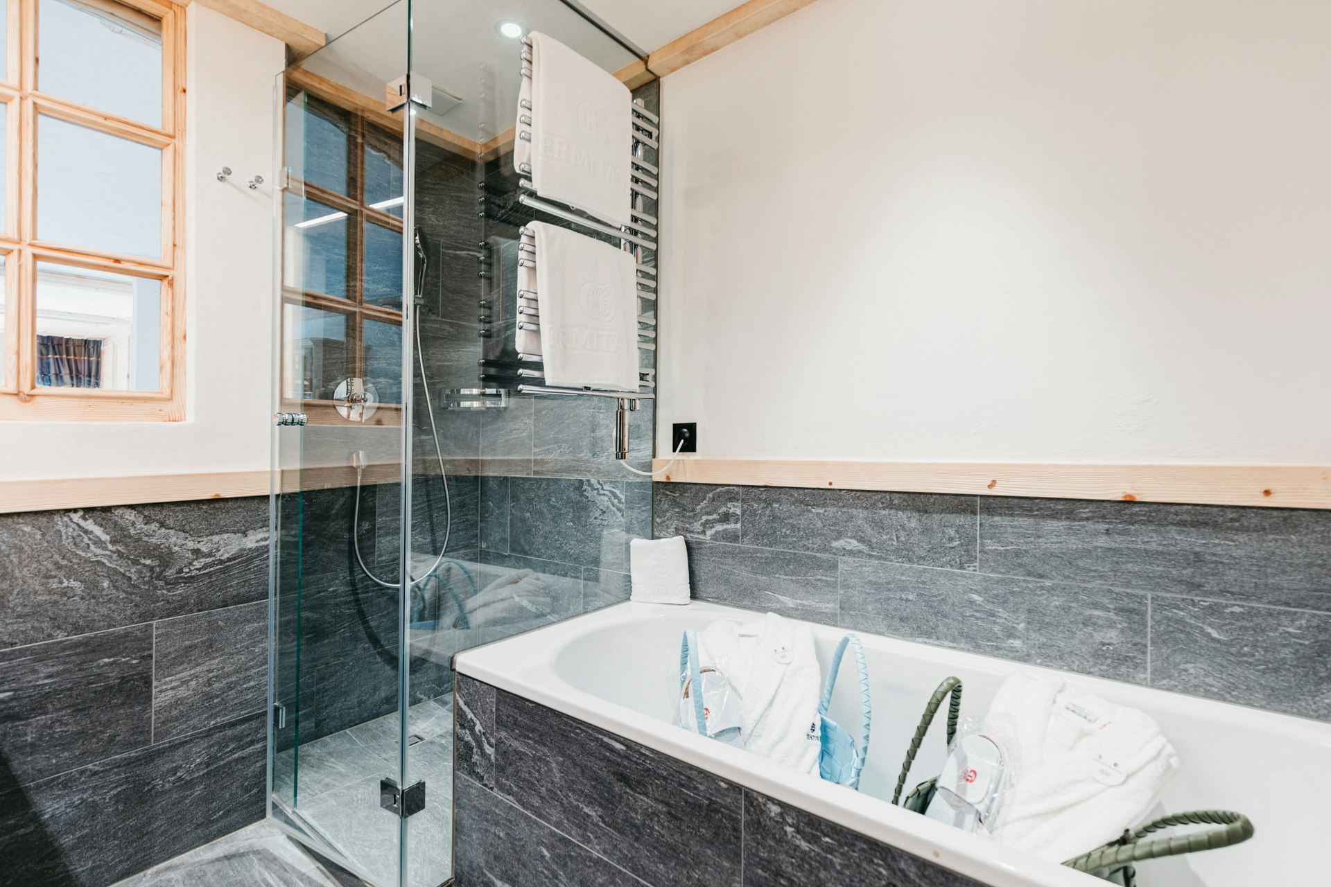 Badezimmer mit Wanne und Dusche, Fenster und Marmorfliesen