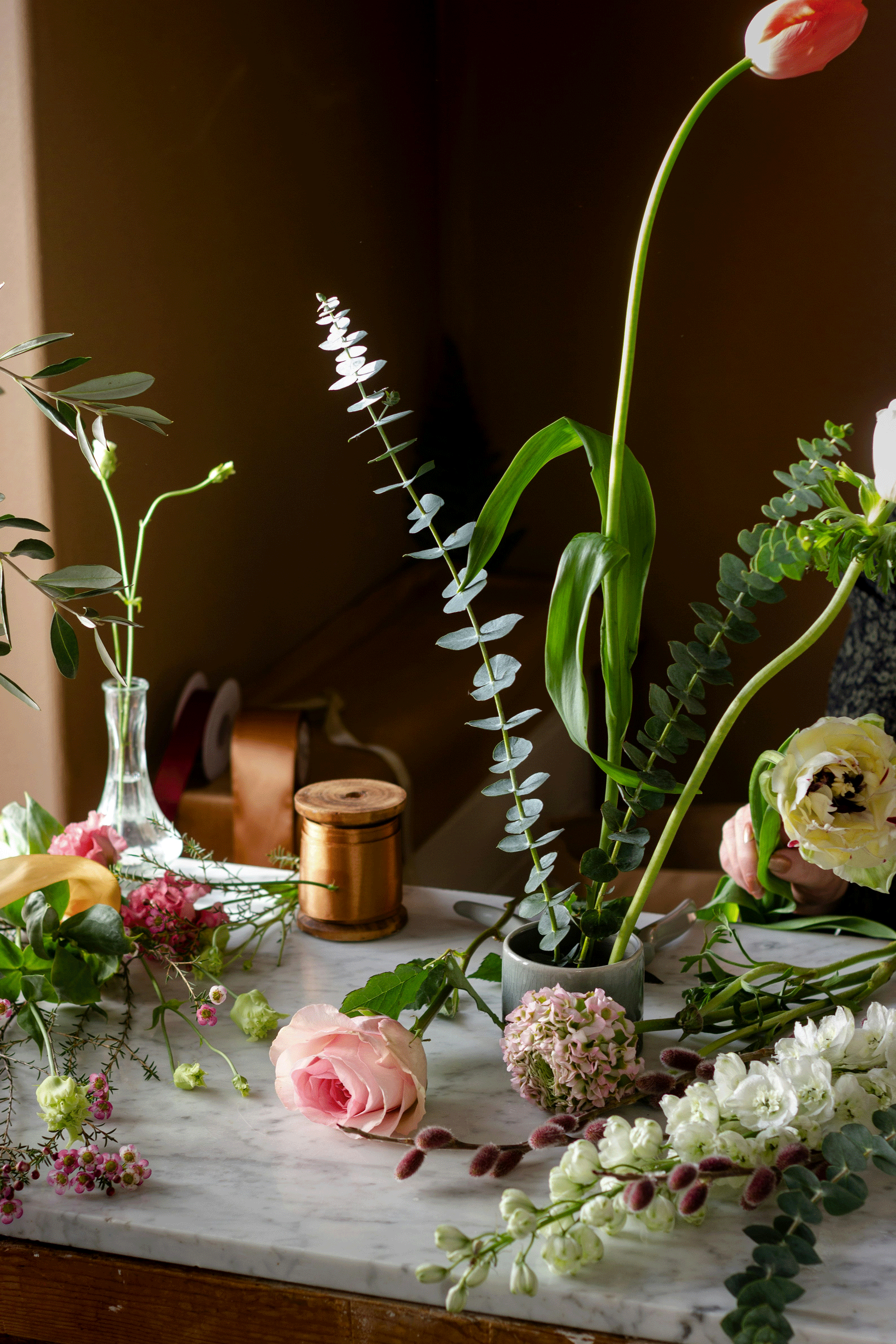 Blumen, Vasen und eine Schnur auf einer Anrichte