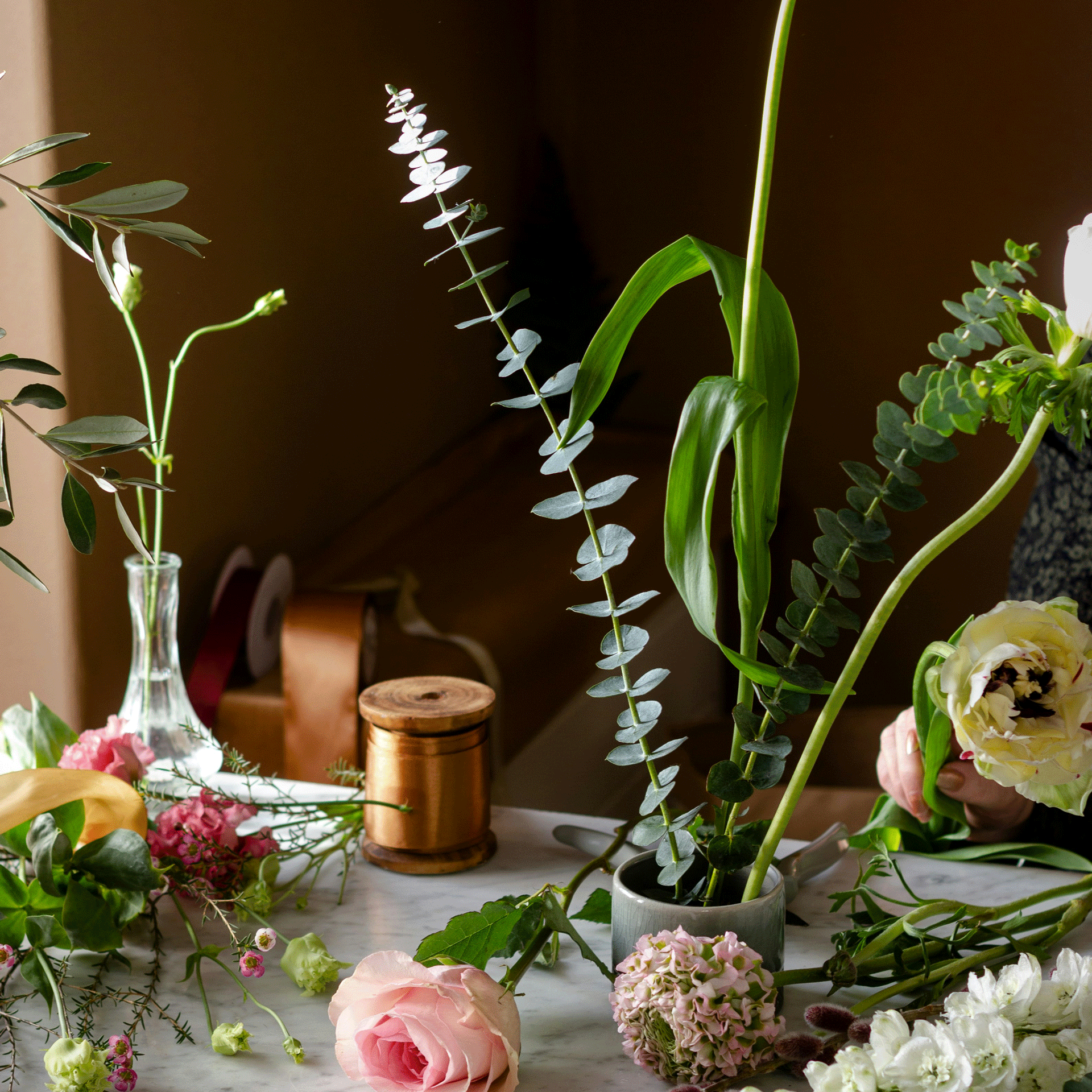 Flower arranging course at the Hotel Ermitage Flowers, vases and a string on a sideboard