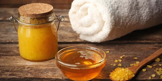 Still life with honey, bath towel and wooden spoon on a wooden base