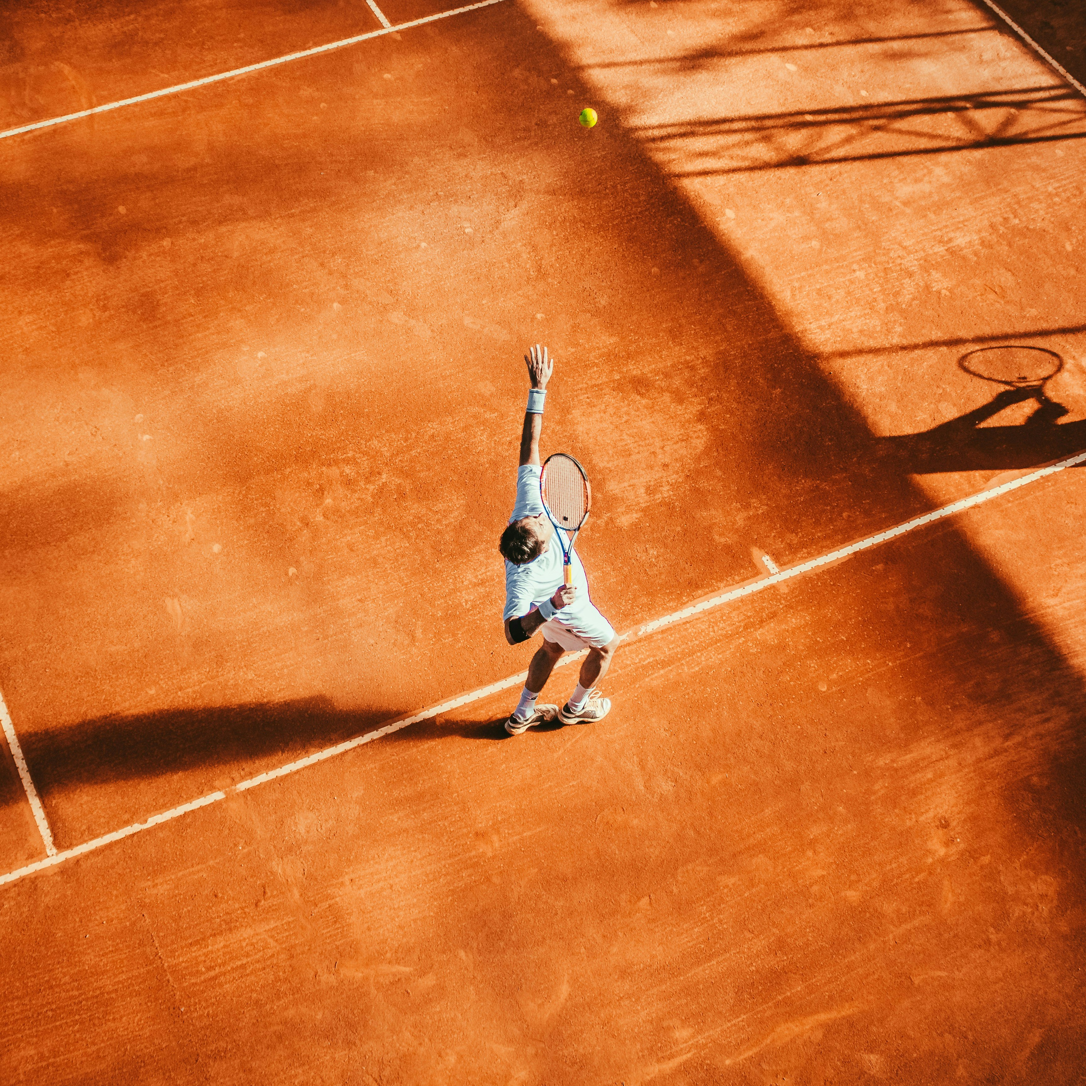 Tennis player Tennis player from above serving in the evening light