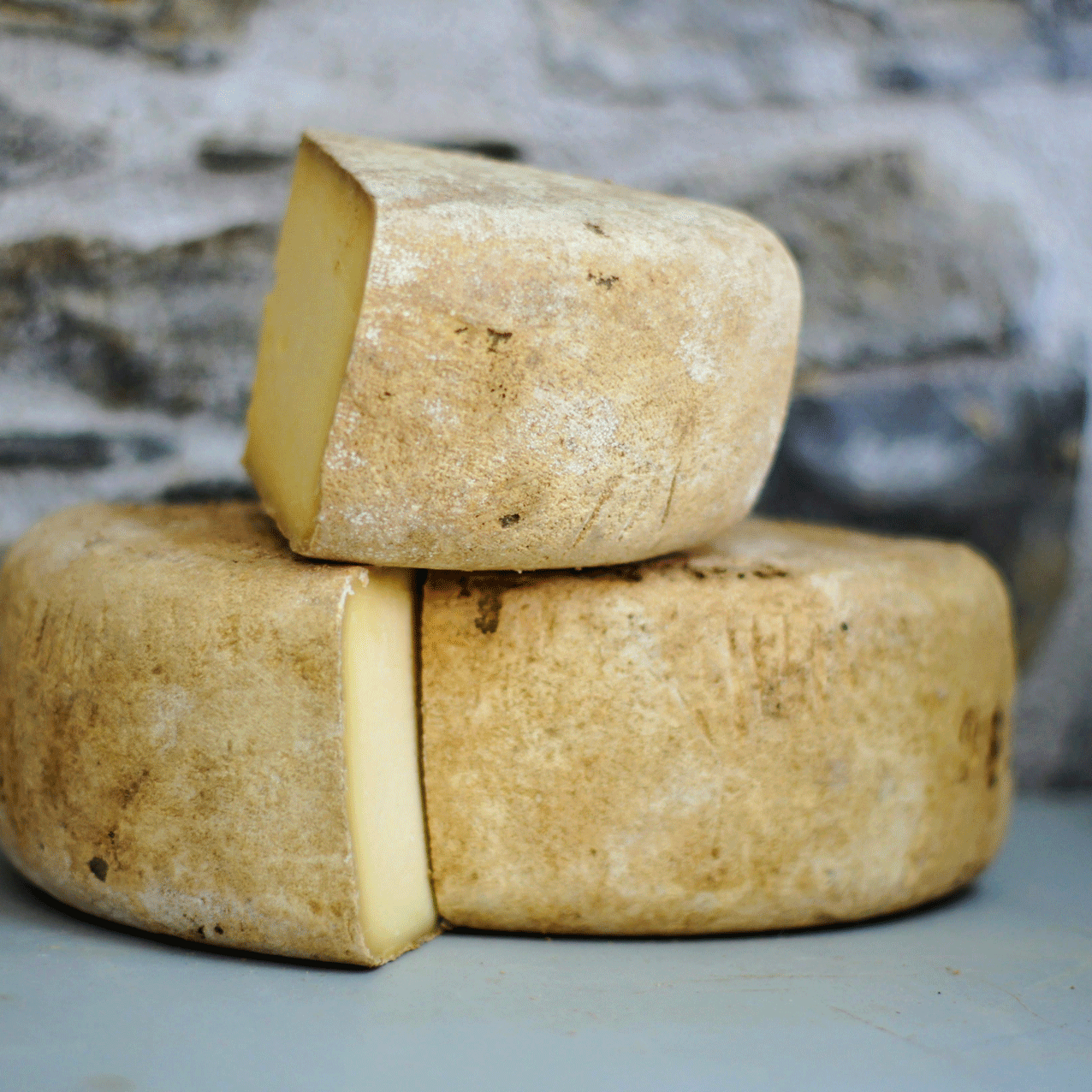 Ermitage kitchen philosophy Three wheels of cheese against a stony background