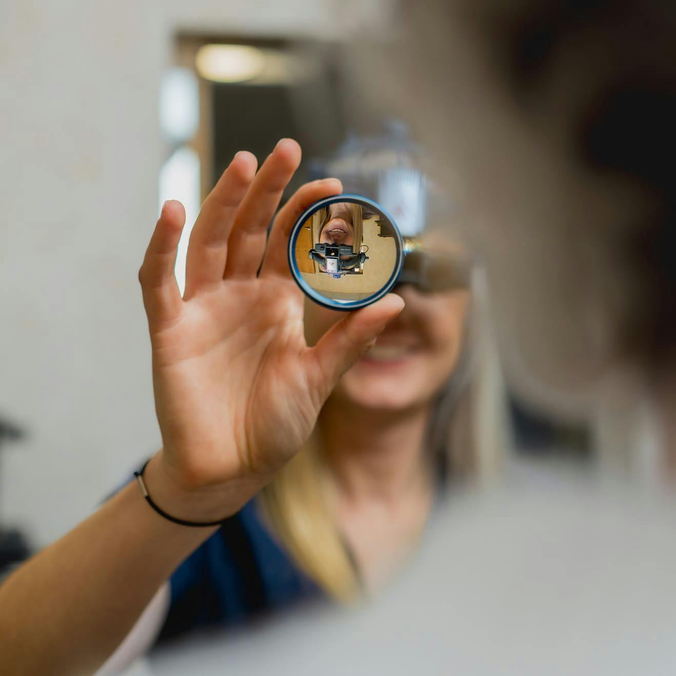 eye specialist holding thick eye lens to patient