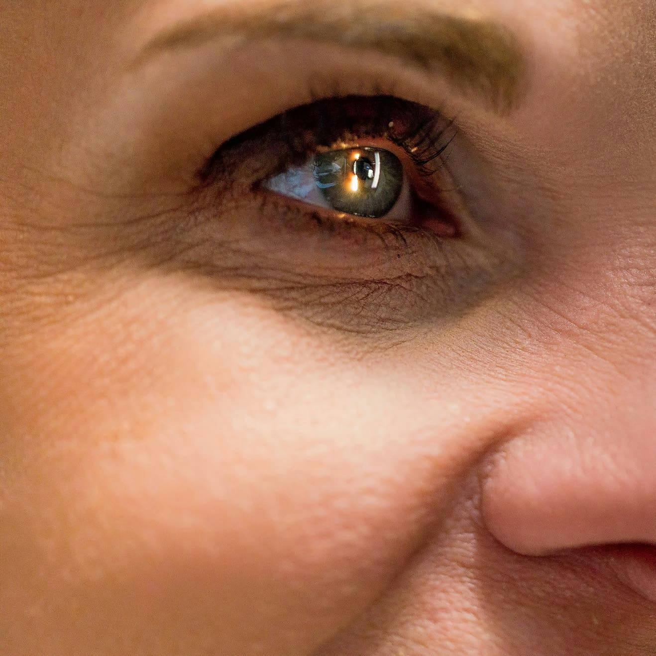 close up on woman's eye with light shining in it