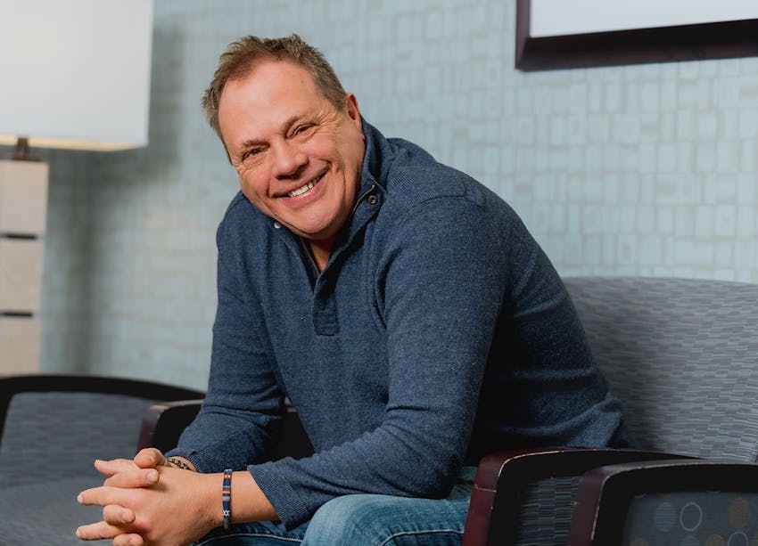 man smiling while sitting in waiting room