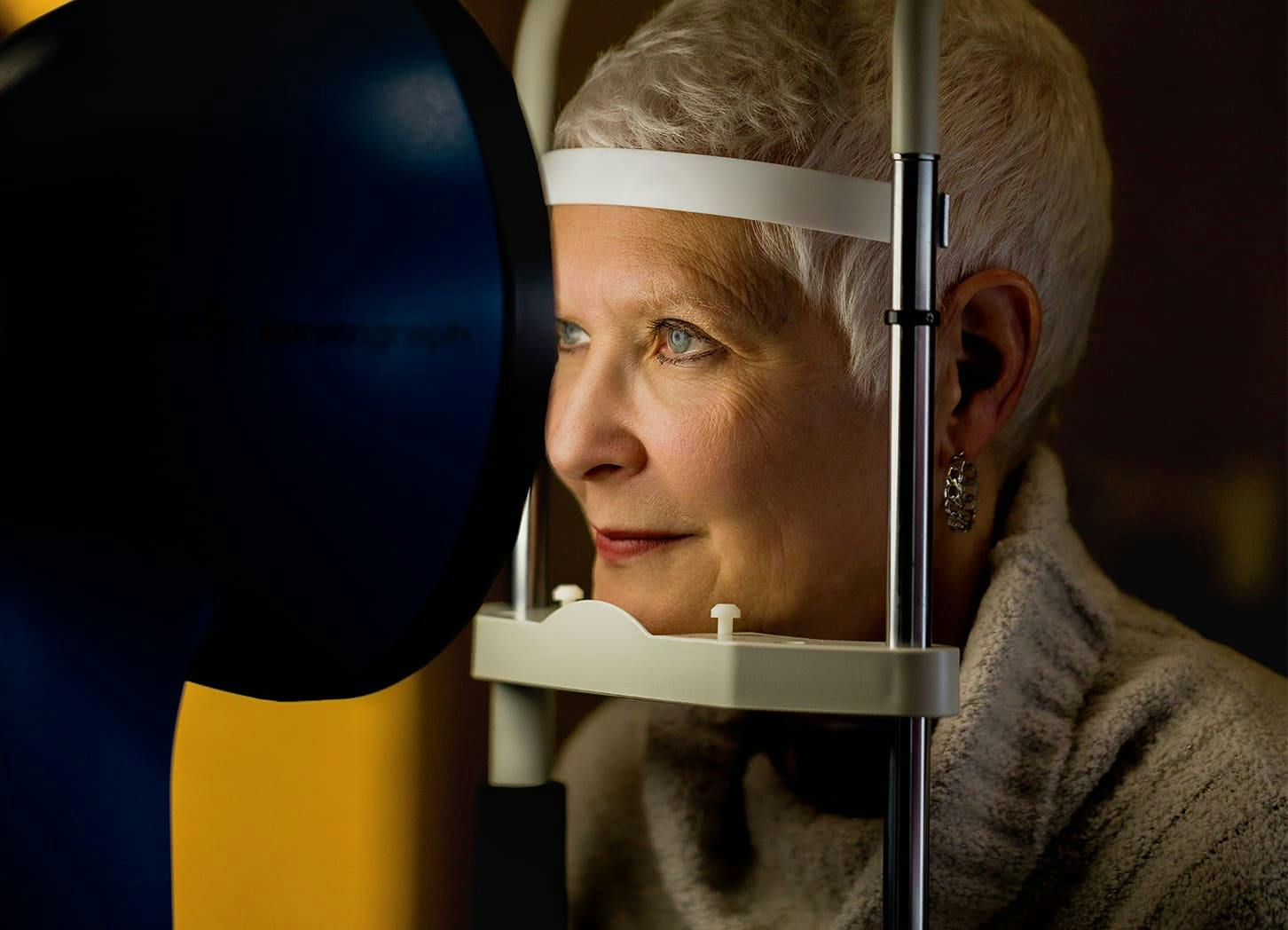 older woman in eye machine to have her eyes looked at