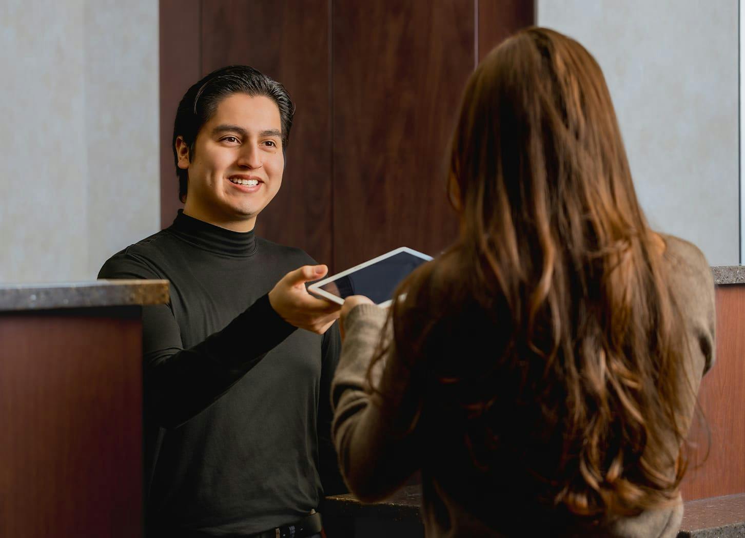 receptionist handing ipad to client