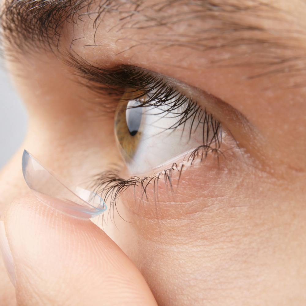 close up of a person putting a contact in
