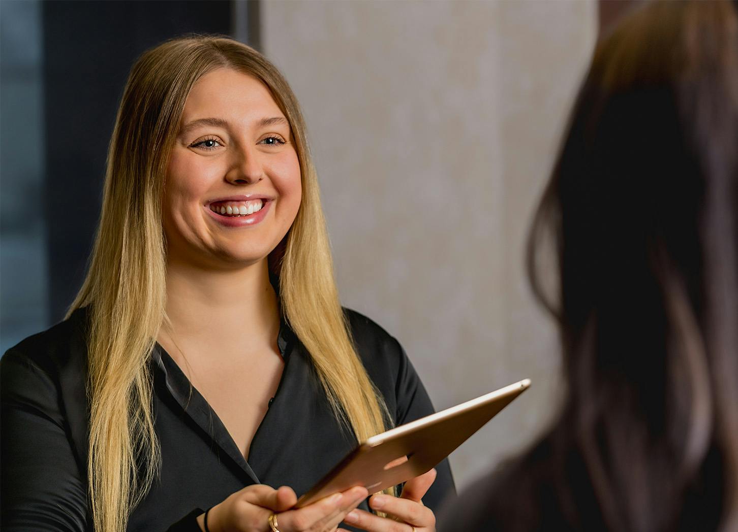 woman handing someone an ipad