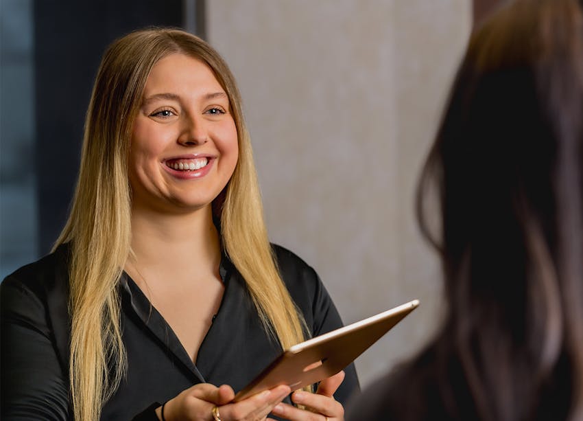 woman handing someone an ipad
