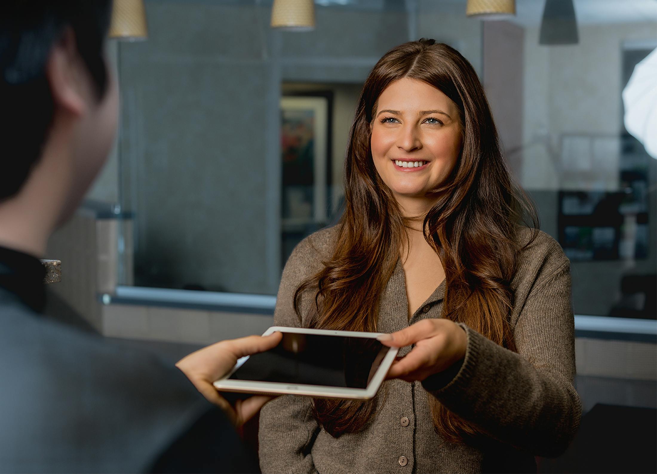 woman handing someone an ipad