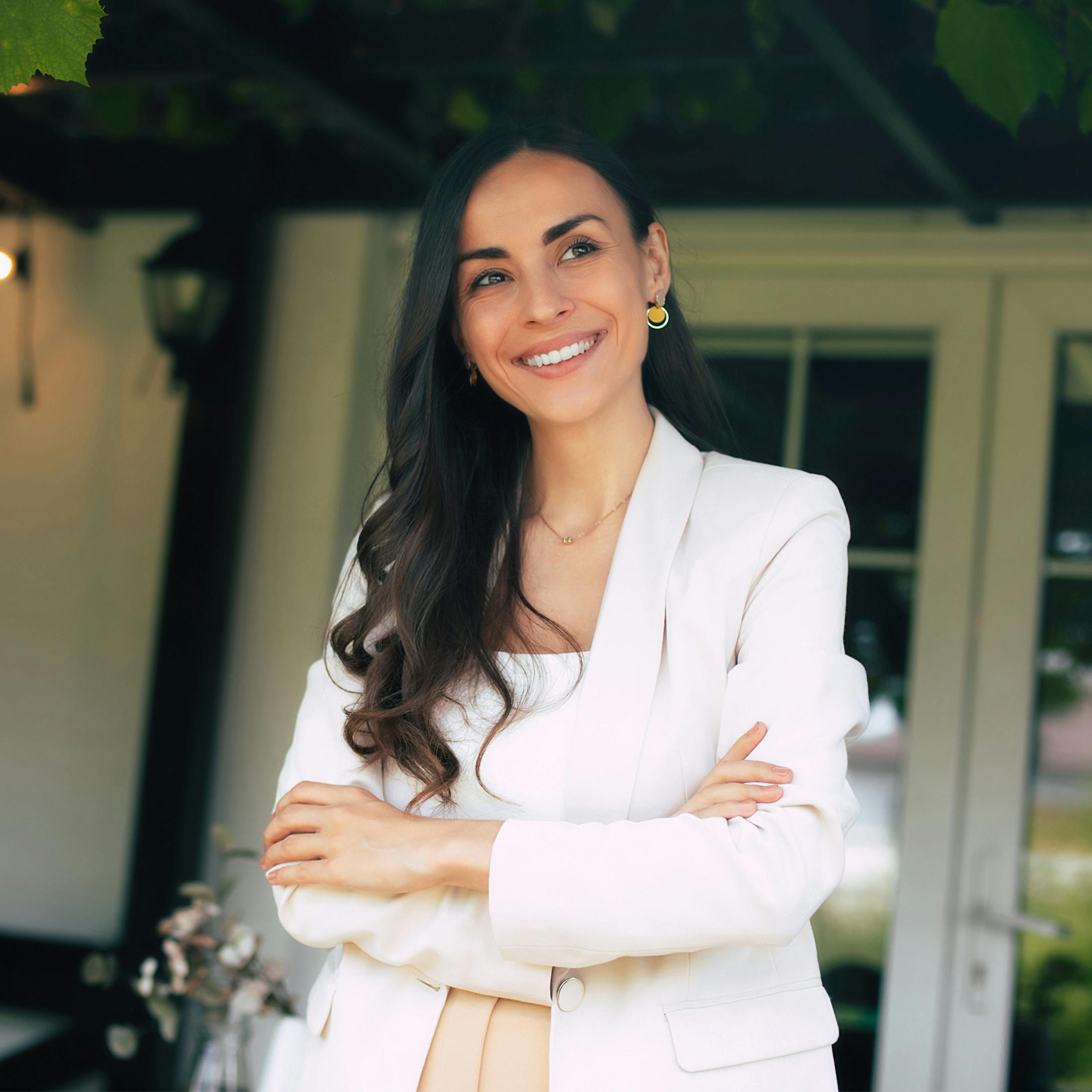 woman with long dark hair wearing a white jacket