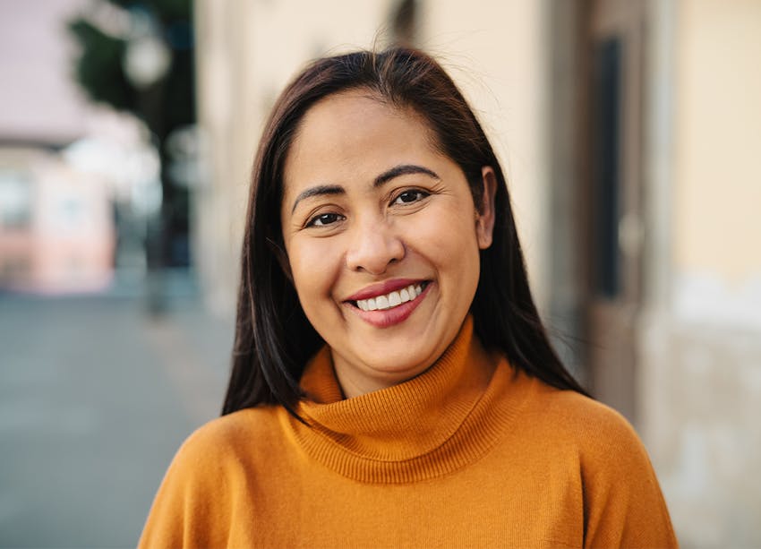woman with orange sweater looking at camera