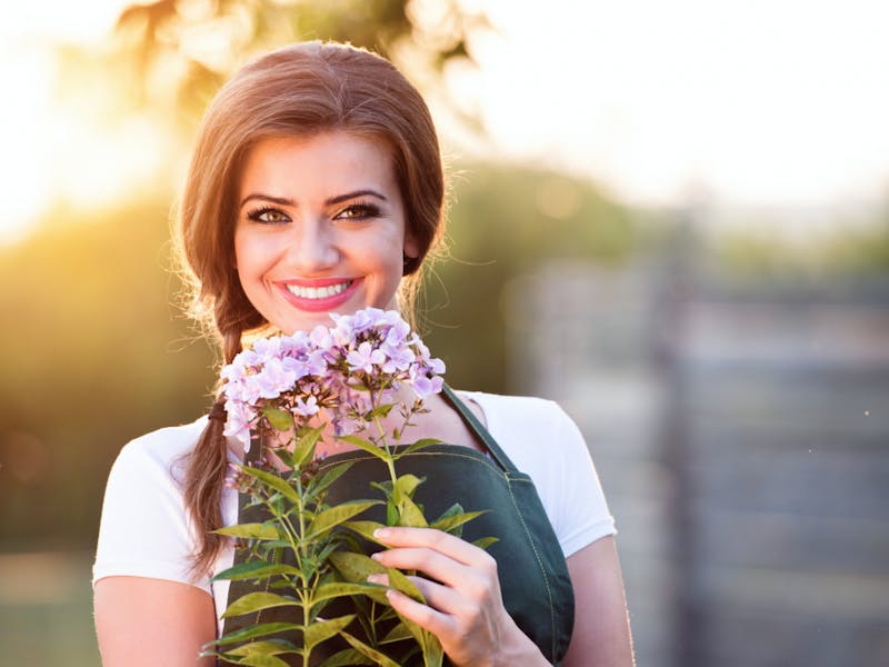 smiling woman holding a bunch of flowers in her hands