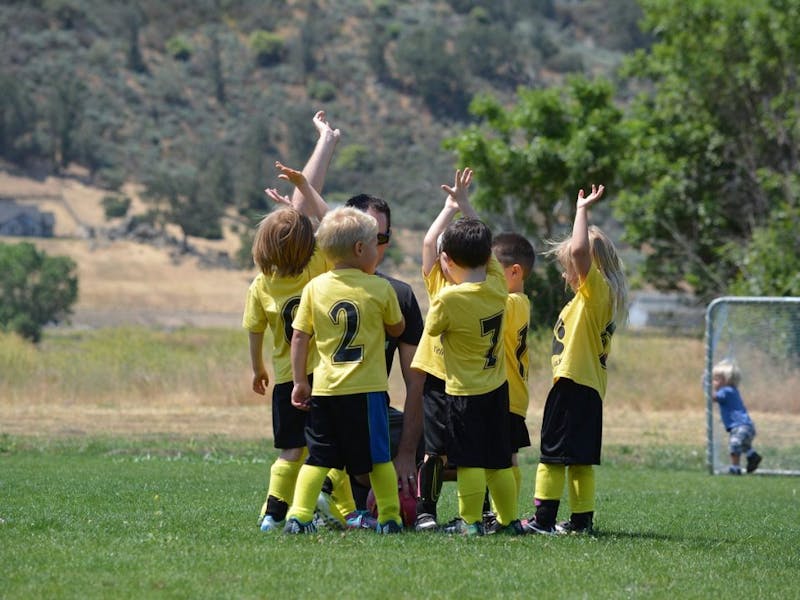 there are many children in yellow shirts playing soccer on a field