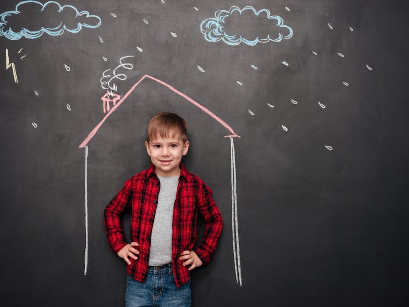 boy standing in front of a chalk drawing of a house