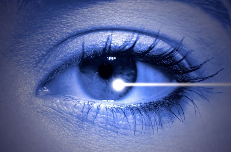 a close up of a person's eye with a laser being pointed into the iris