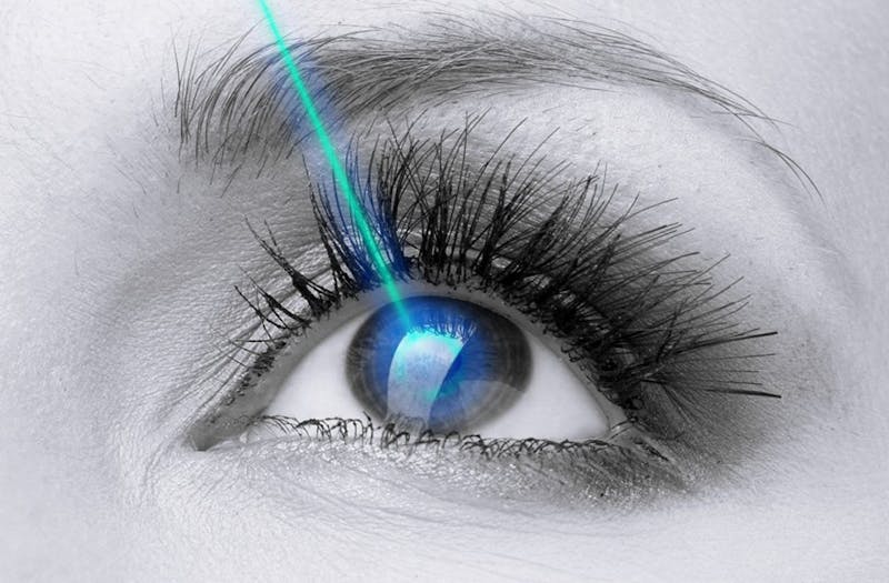 a close up of a woman's eye with a laser being pointed into it