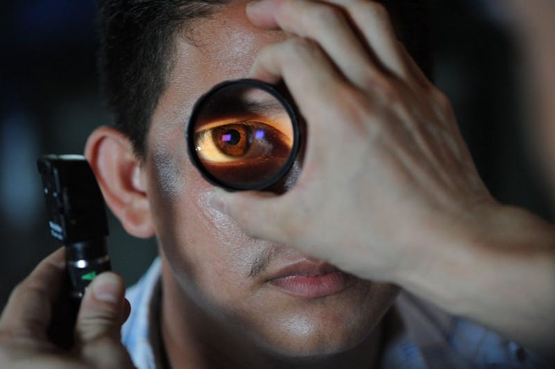 a man is doing an eye exam in dark room