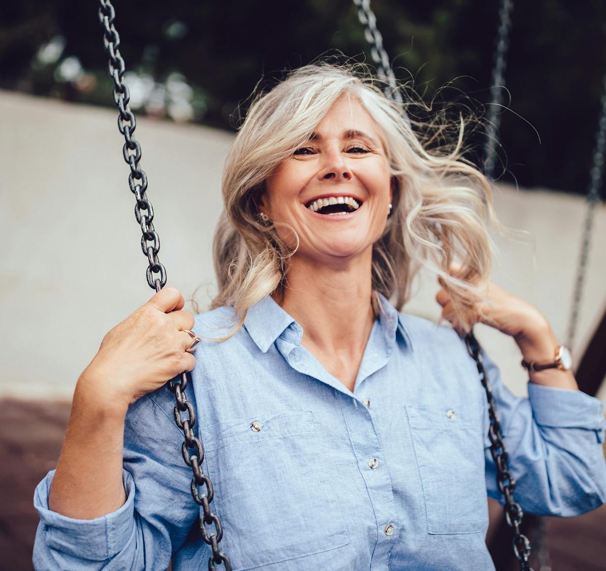 smiling woman on a swing with a blue shirt on