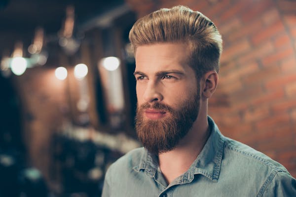 man in a green shirt is looking off into distance in restaurant