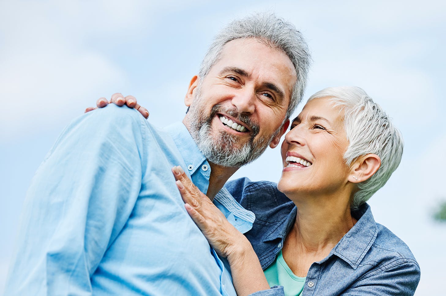 smiling older couple embracing each other in a park