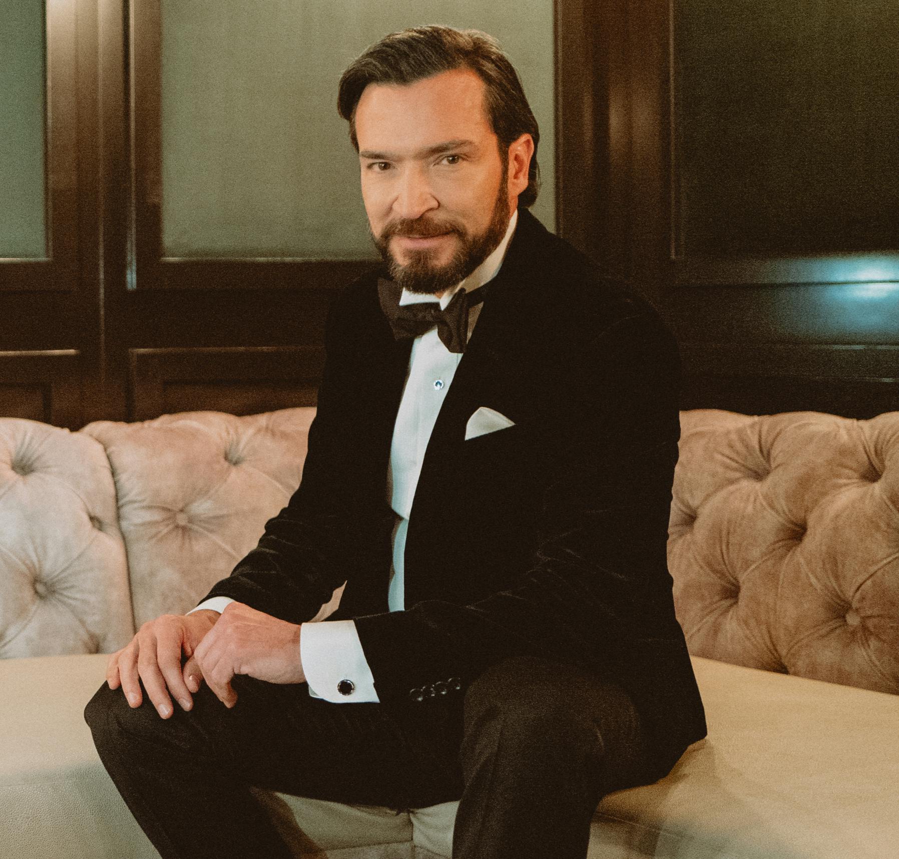 Dr. James Kelly with Kelly Vision Center in tuxedo sitting on couch