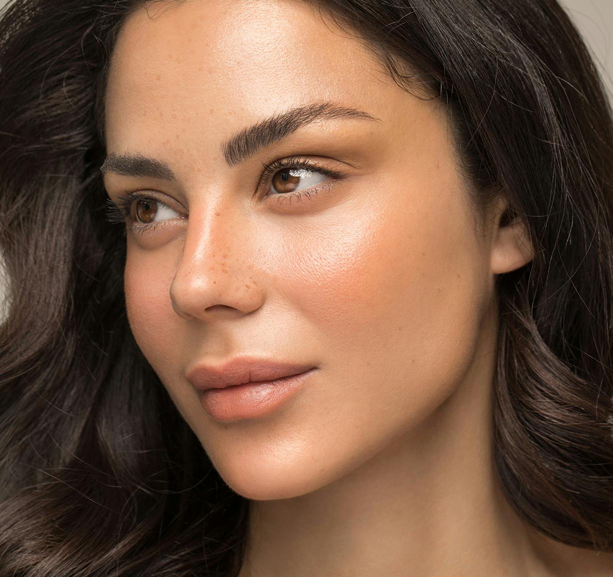 a woman with long hair and a necklace on posing for photo