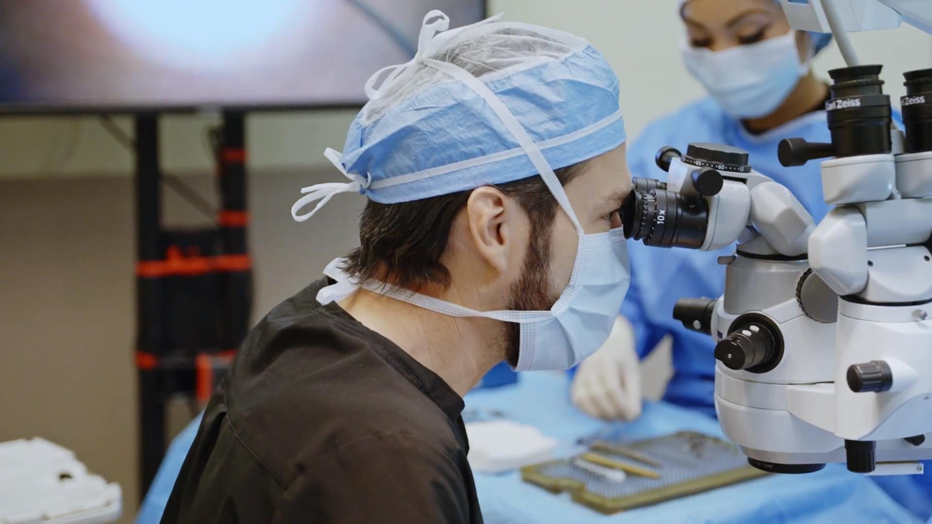 Dr. James Kelly performing eye surgery in scrubs