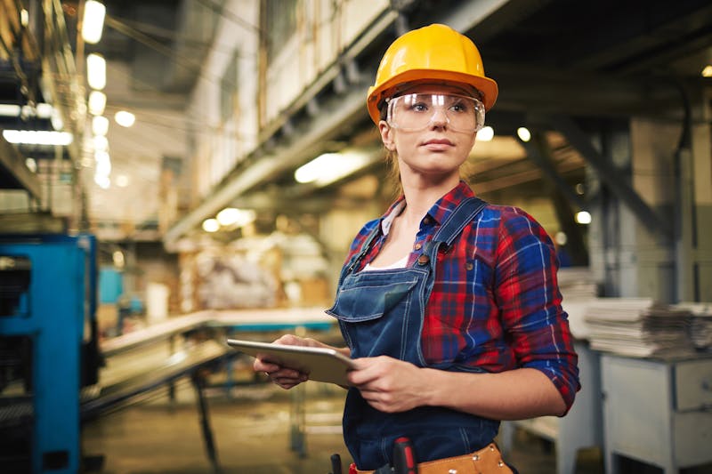 Woman in a factory with a helmet and goggles