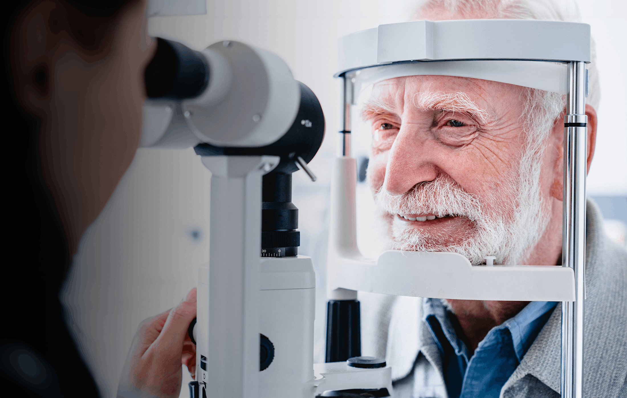 older man getting eye exam done by a doctor