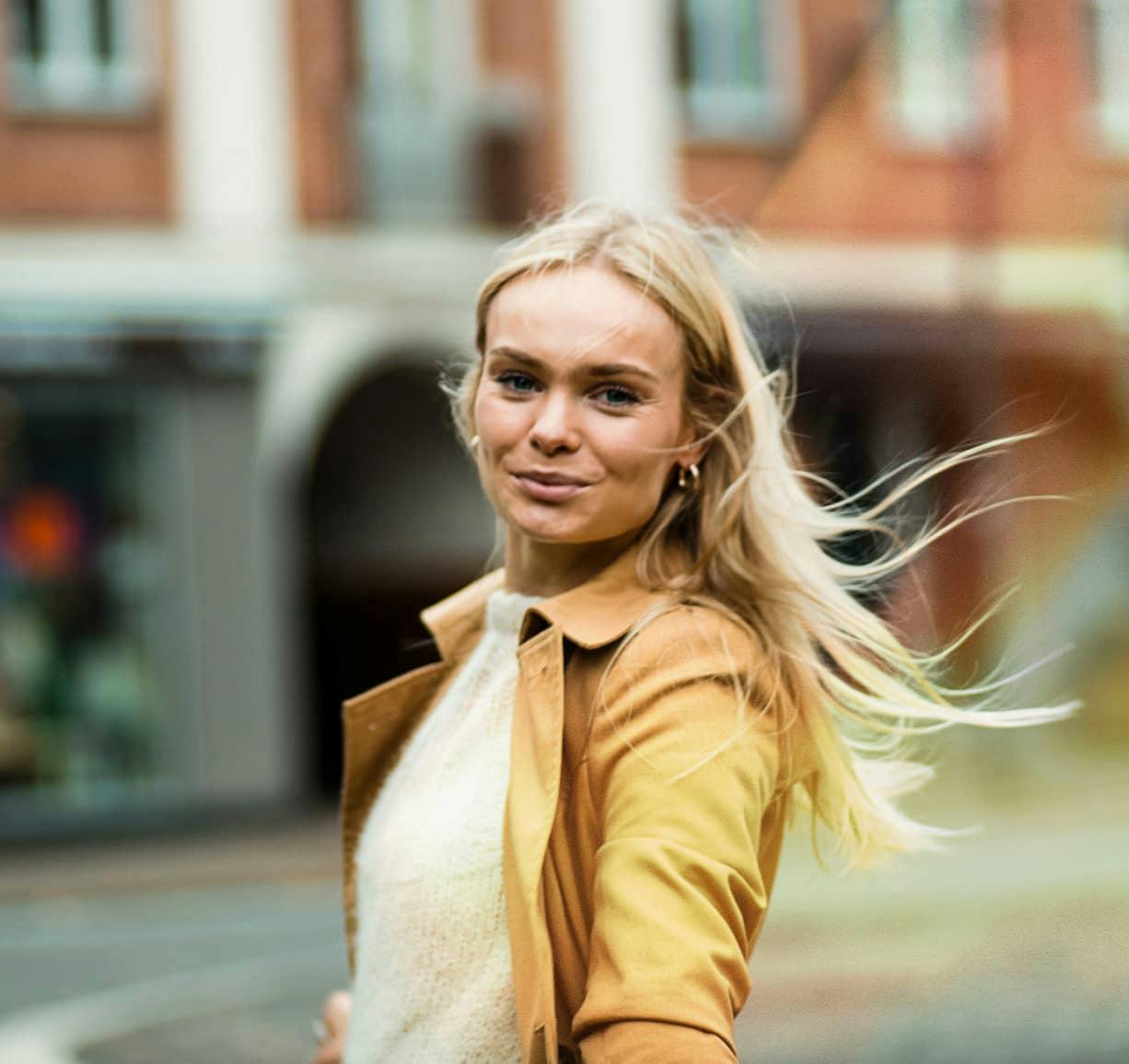 a woman looking over her shoulder and smiling into the camera