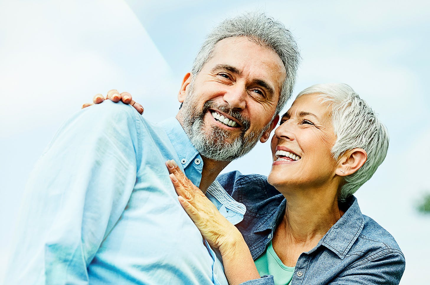 woman with her hands around a man while both are smiling