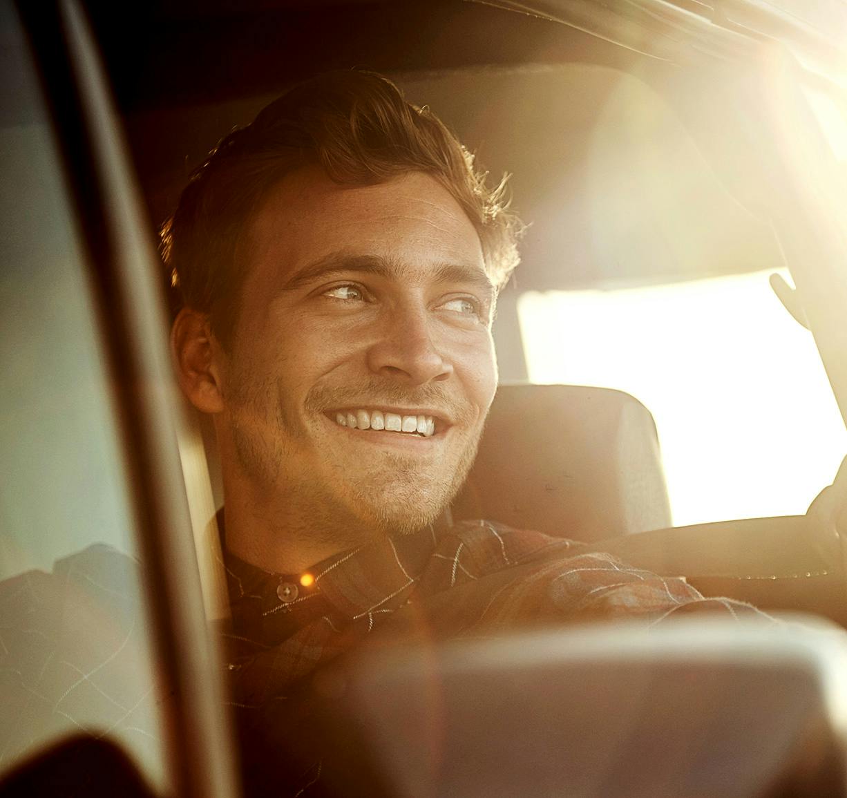 man looking out car window and smiling