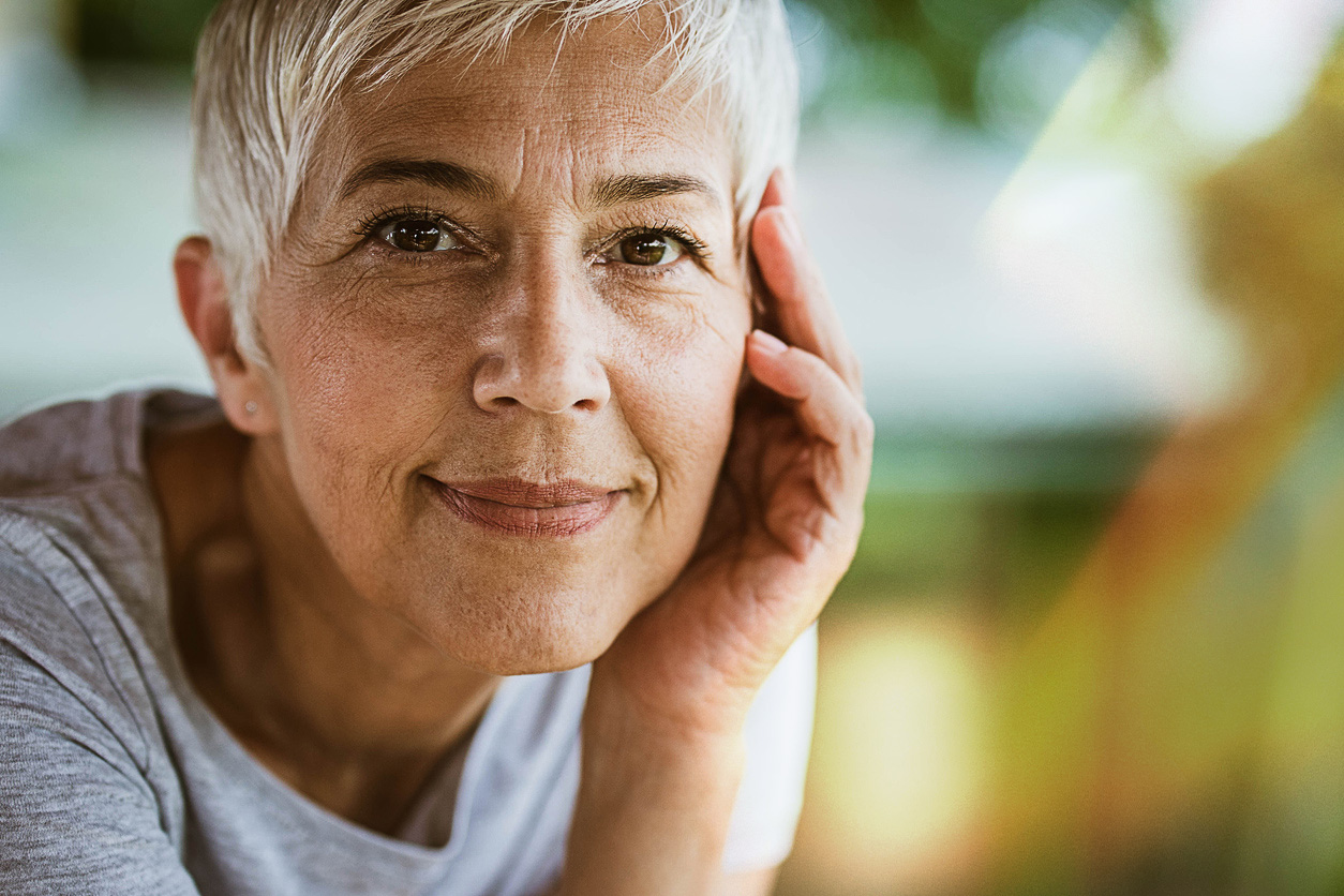 Lady with one hand on her face and smiling