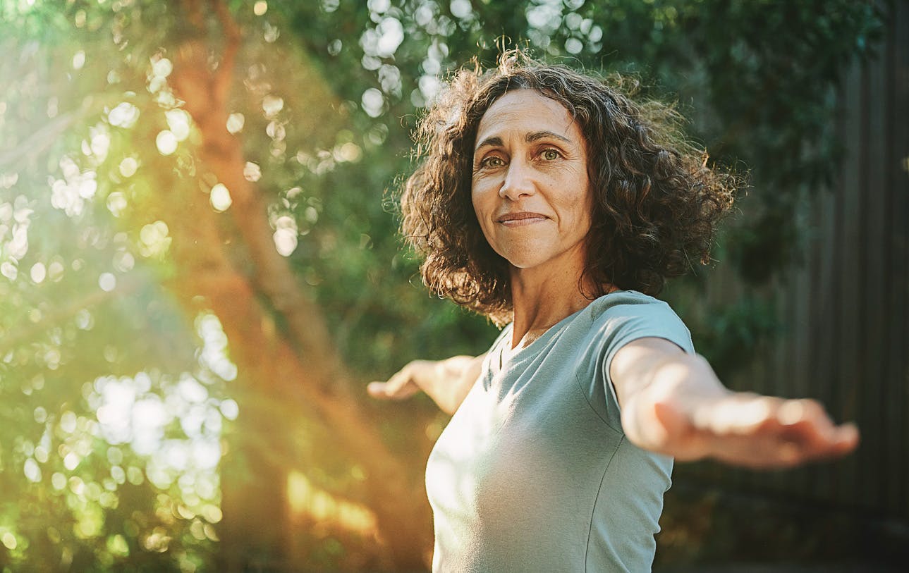 lady with her arms stretched out while she's looking over her shoulder smiling