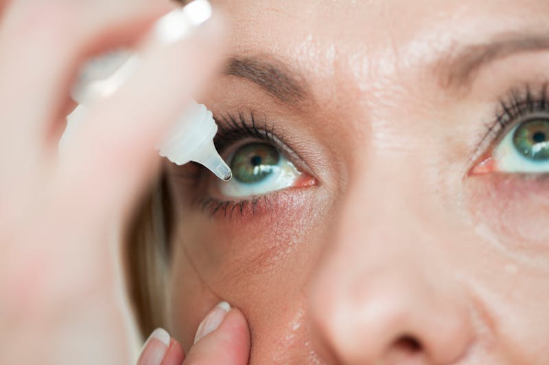 Woman using eye drops